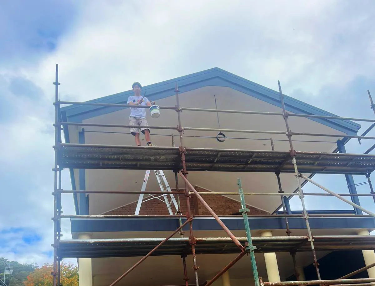 Terry Tibet painting a house